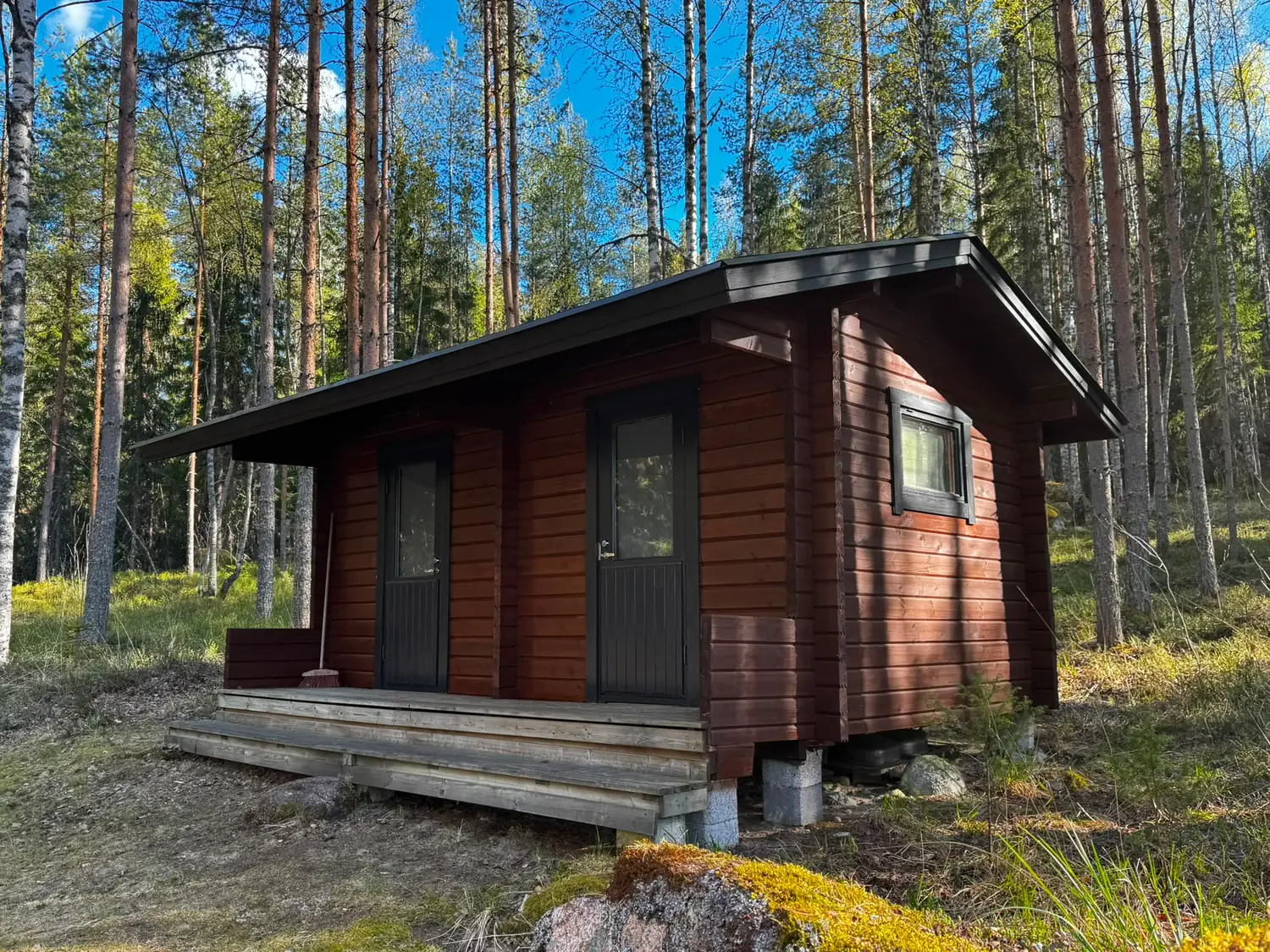 Tummanruskeaksi maalattu puurakennuksen julkisivu